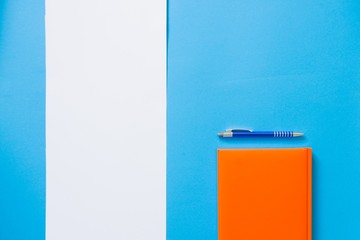 Top view blue desk table. Office tools on colored background. Flat lay of workspace