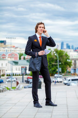 Young successful businessman calling by phone