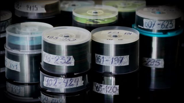 Compact Optical Dvd or cd Discs in Plastic Boxes Standing on Table