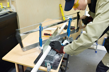 Master electrician sawing plastic box for laying wires