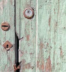 Fragment of the old vintage door with rusty keyholes