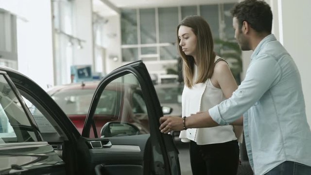 Sad girl don't want to buy a car, which chose her boyfriend in car showroom