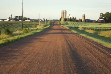 Abwaschbare Fototapete Rural Minnesota road with farms in morning light © Daniel Thornberg