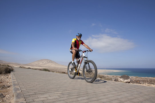 Spain, Canary Islands, Fuerteventura, Senior Man On Mountain Bike