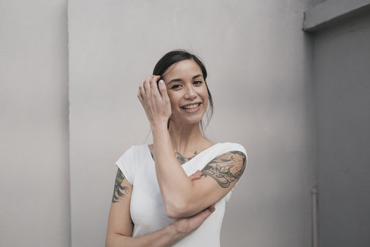 Portrait of a young woman with tattoos, smiling
