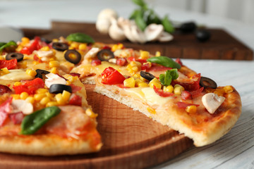 Plate with tasty pizza on wooden table, close up view