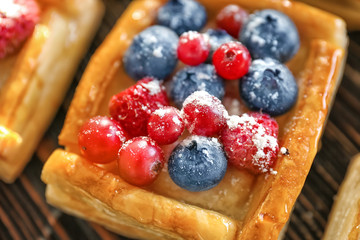 Delicious puff pastry with berries and sugar powder, closeup