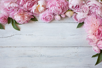 Pink flowers peonies and roses on a white wooden background, space for greeting text - obrazy, fototapety, plakaty