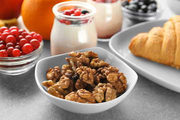 Bowl with nuts and served breakfast on table