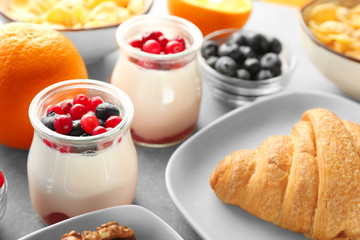 Jar with yogurt and served breakfast on table