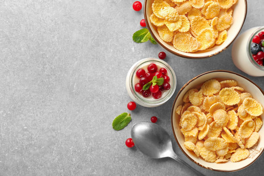 Tasty breakfast with corn flakes on light background