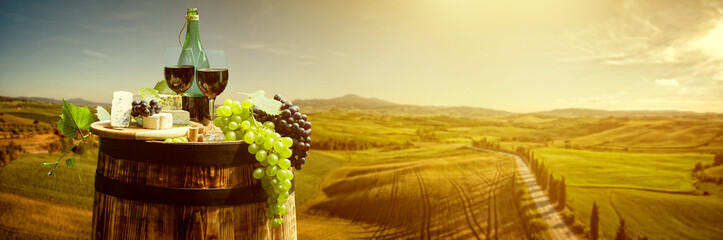 Panele Szklane  Czerwone wino z beczką na winnicy w zielonej Toskanii we Włoszech