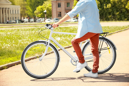Sporty young man with bicycle outdoors