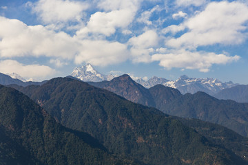 Kangchenjunga mountain with clouds above. Among green hills that view in the evening in North Sikkim, India.