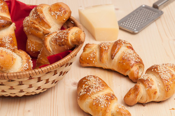 Croissants with sesame and cheese, pastry on wood