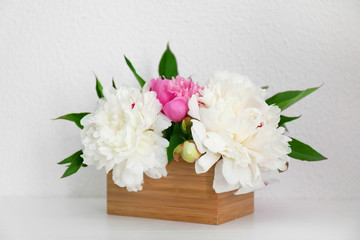 Beautiful bouquet with fragrant peonies on light background
