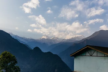 Cercles muraux Kangchenjunga Kangchenjunga mountain with clouds above. Among green hills and house with electric cable that view in the evening in North Sikkim, India.