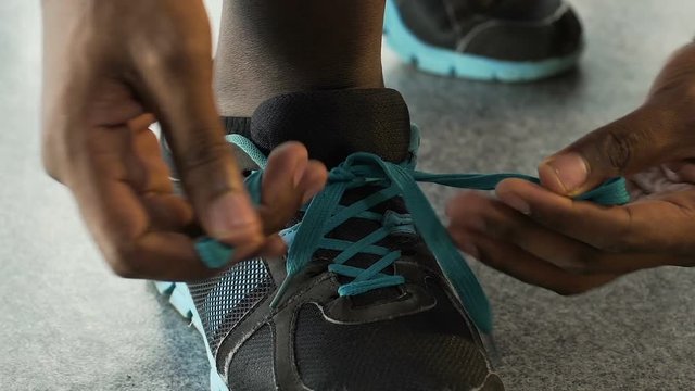 Multiracial guy tying up shoelaces and leaving, basketball player, close-up