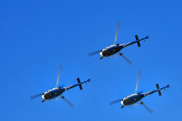 three helicopters in the blue sky