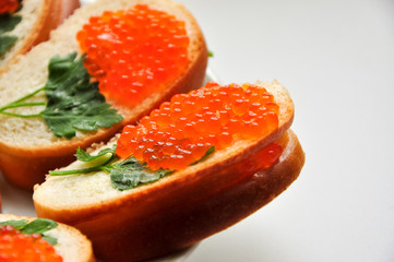 Photo of baguette with red caviar on white table