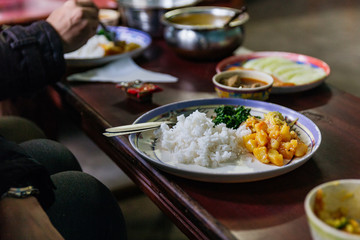 Steamed rice with curry soup and vegetables on the plate at tourist stop restaurant in North Sikkim, India.