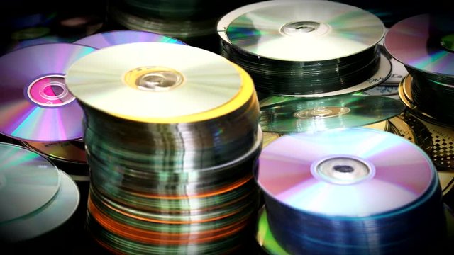 Piles of Compact Optical Dvd or cd Discs Standing on Table