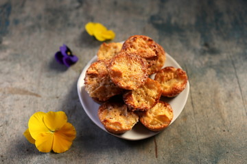 Muffins and flowers on a wooden background. Mafins on a dark wooden background with flowers. Homemade baking. Mini apple charlottes.