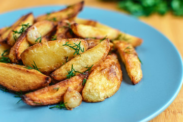 Roasted potatoes with salt pepper and cumin on wooden background