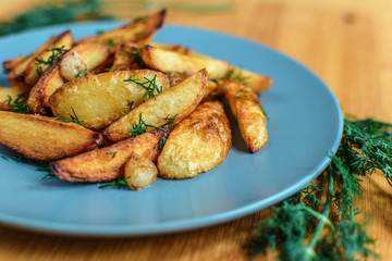 Roasted potatoes with salt pepper and cumin on wooden background