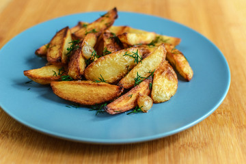 Roasted potatoes with salt pepper and cumin on wooden background