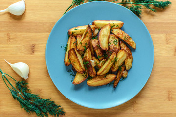 Roasted potatoes with salt pepper and cumin on wooden background