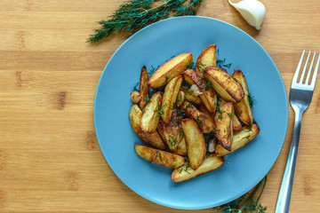 Roasted potatoes with salt pepper and cumin on wooden background