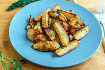 Roasted potatoes with salt pepper and cumin on wooden background