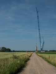Fototapeta na wymiar building a new wind power plant with a big blue crane