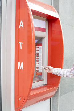 Hand of a man with a credit card, using an ATM. Man using an atm machine with his credit card.