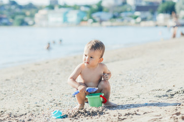 little boy on the beach near the sea plays