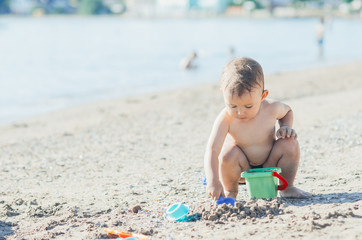 little boy on the beach near the sea plays