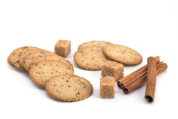 Biscuits, cane sugar, cinnamon sticks on white background