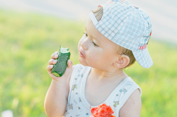 the child greedily eating cucumber