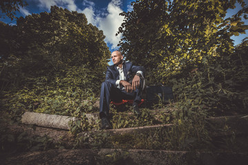 Serious man sitting on a old broken stairs