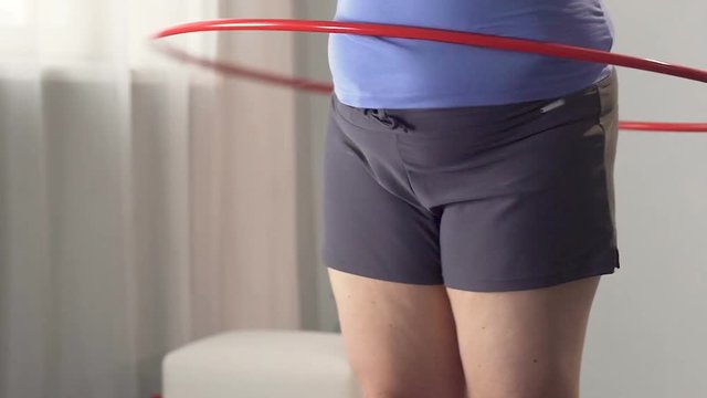 Girl with extra weight spinning hula hoop, burning belly fat exercising, workout