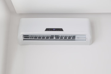 White split air conditioner on a white wall. Home interior in a small apartment