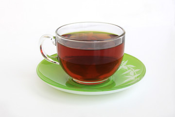 glass Cup with tea on a green saucer on a white background