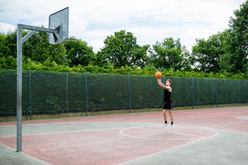 Obraz premium Teenage boy shooting a basketball on a court