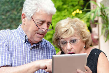 Elderly couple using tablet.