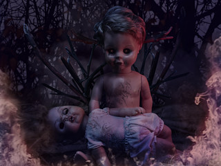Horror dolls photo. Two burning dirty creepy dolls sitting and lying on tree branches photo.
