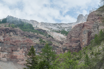 Triassic colorful  layers overlain by dolomitic rocky reefs, Bletterbach canyon, Dolomites, Italy