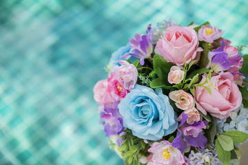 Beautiful colorful flower bouquet over blurred swimming pool background