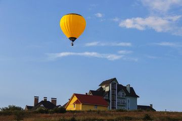 Fototapeta na wymiar Yellow balloon in blue sky in Schodnica, Ukraine