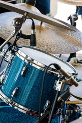 drum with copper cymbals of a drum kit standing on street scene